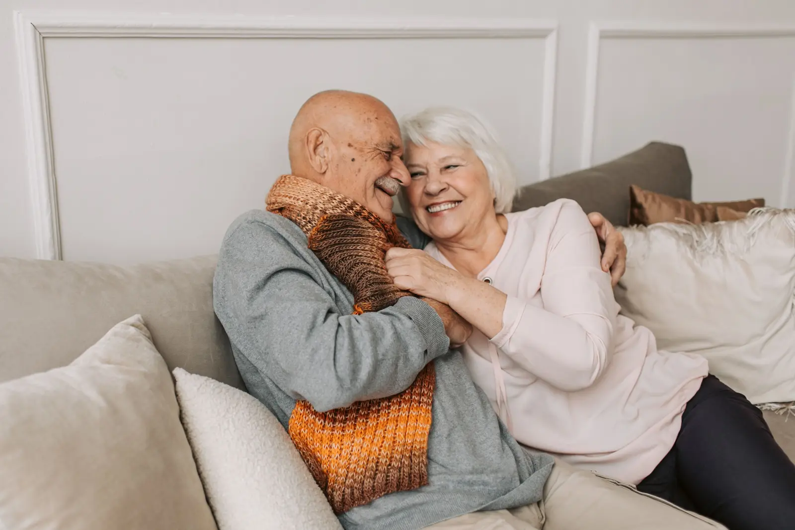 An older couple laughing together at home