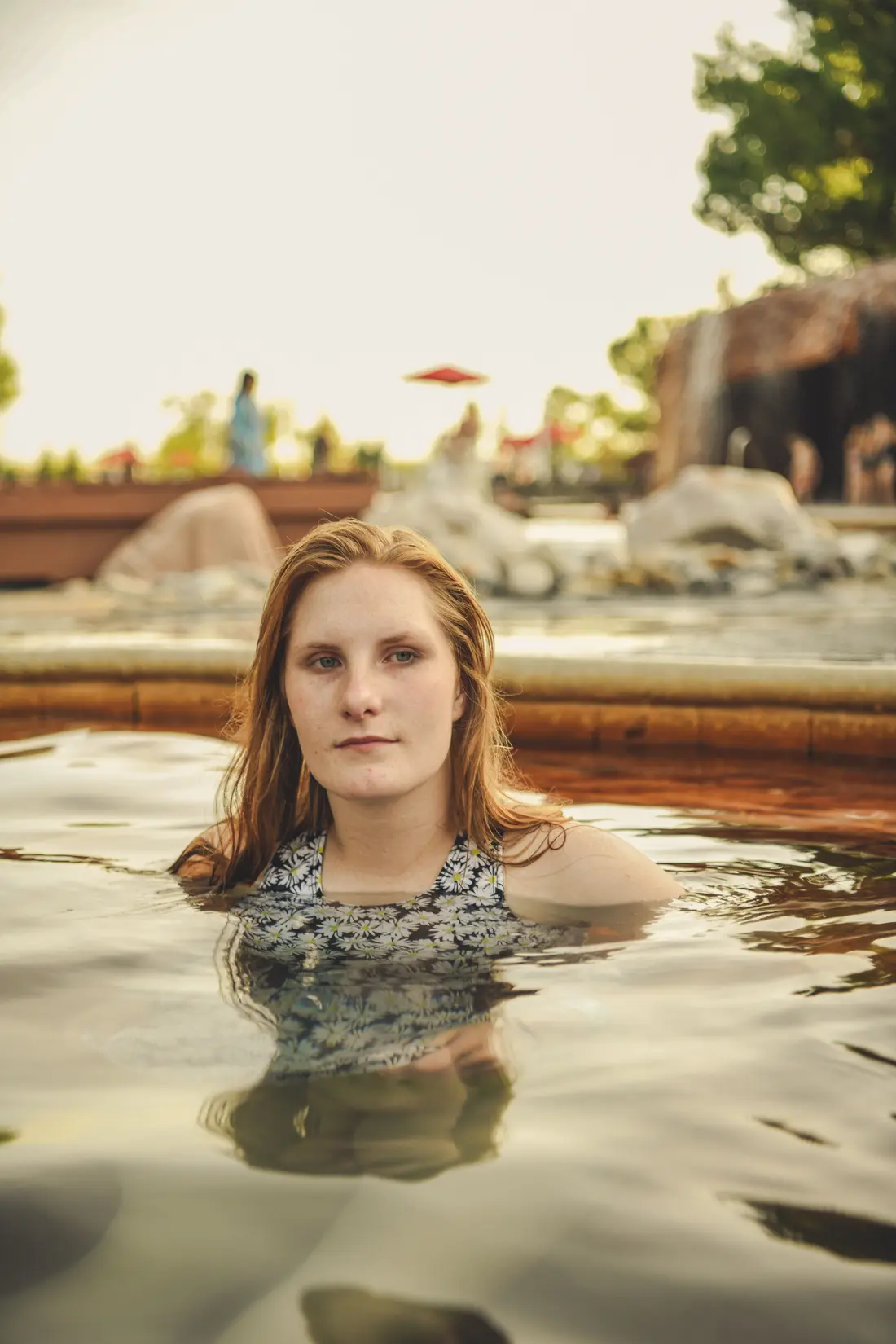 A woman relaxing in a steaming outdoor thermal pool