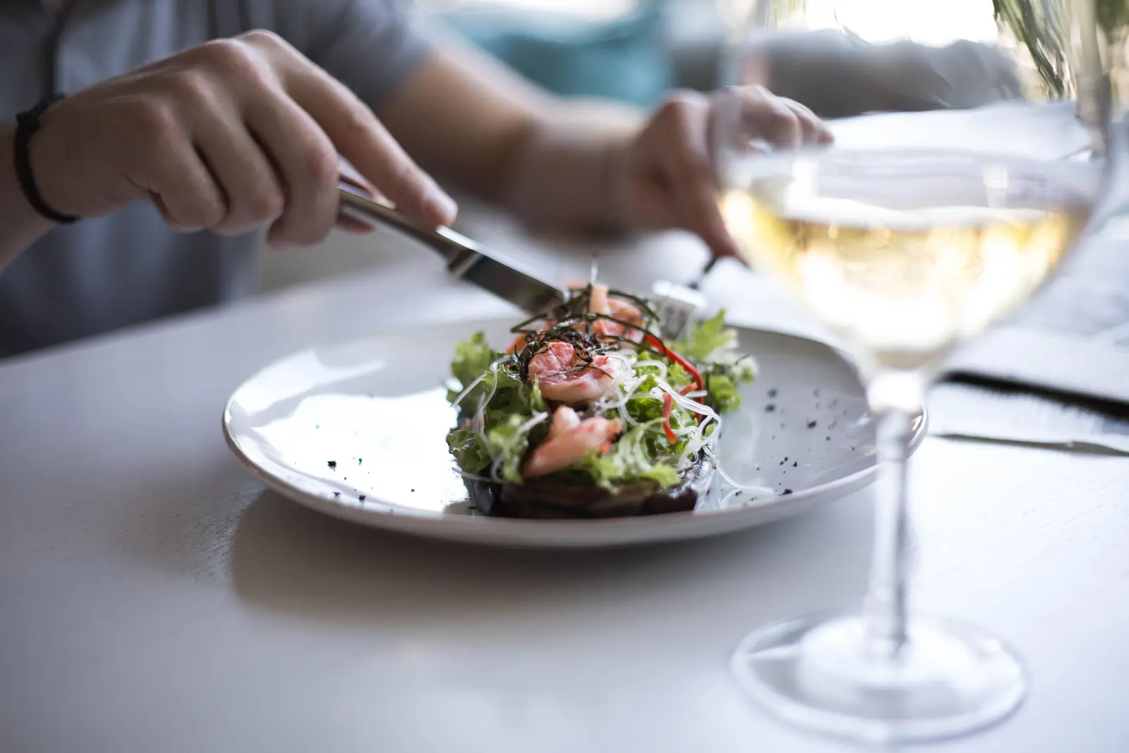 A beautifully plated meal with a glass of wine